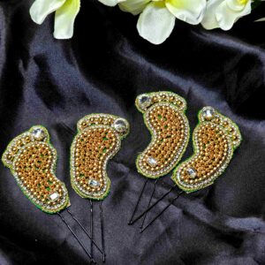 Footprint-shaped brooches in metallic finish